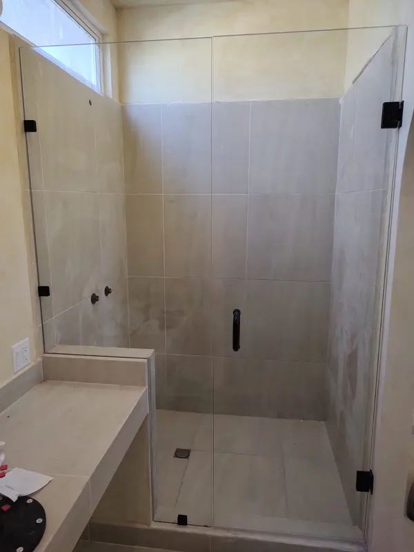 Frameless glass shower enclosure